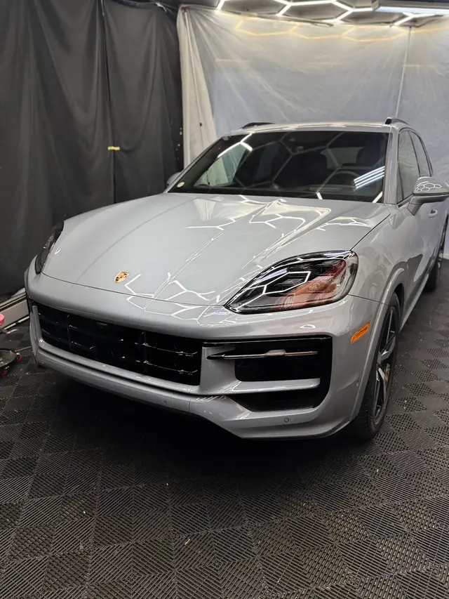 Silver Porsche Cayenne under the hexagon lights in the detail bay at 400 High St