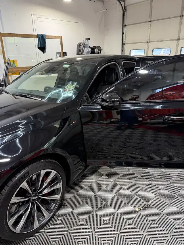 Black SUV with a mirror finish on the checker floor of the bay