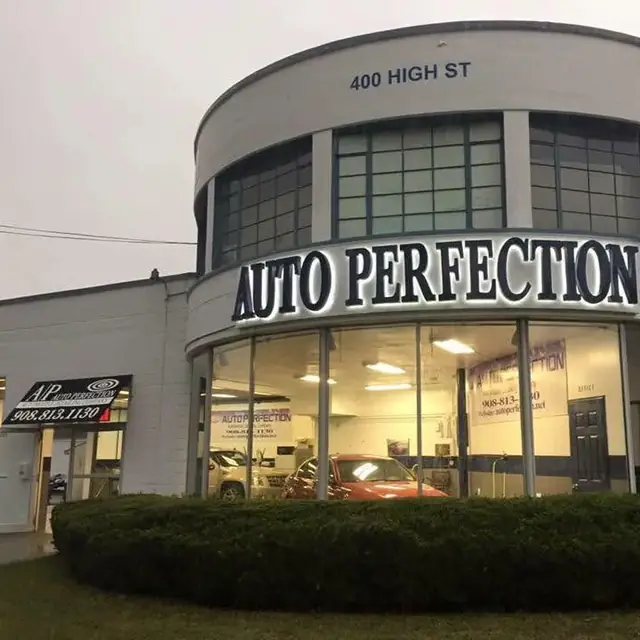 The lit AUTO PERFECTION channel letters on the rotunda at 400 High St